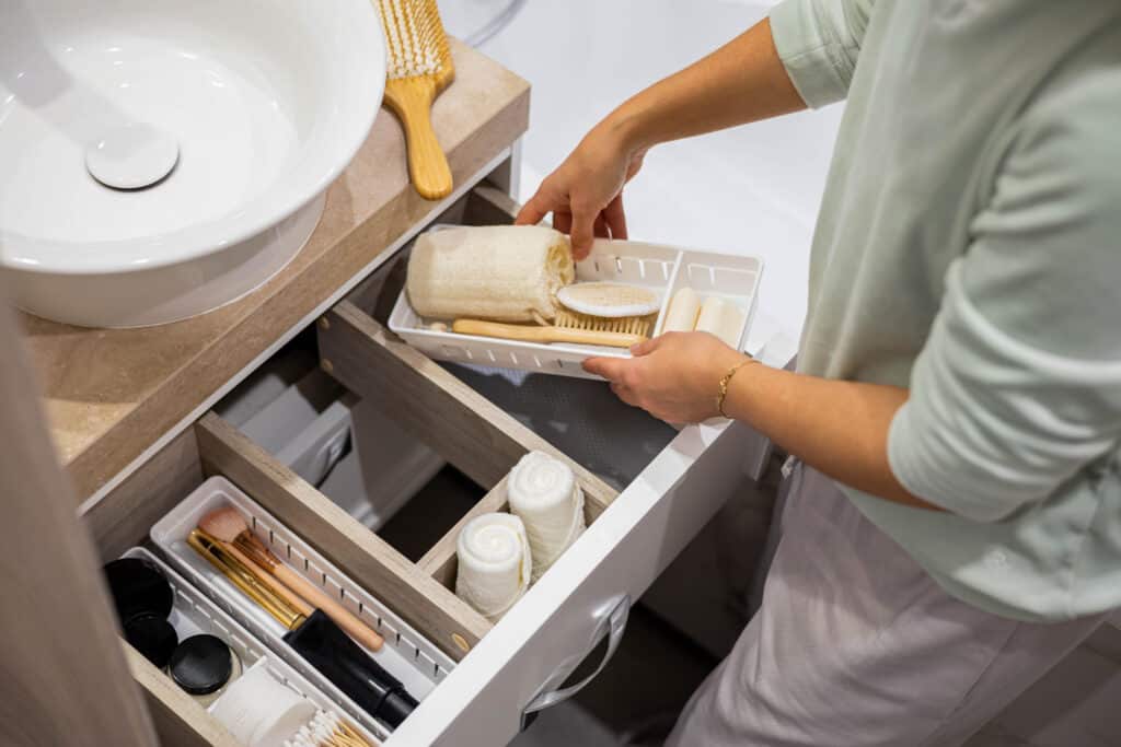 Placing organizing products into a bathroom drawer