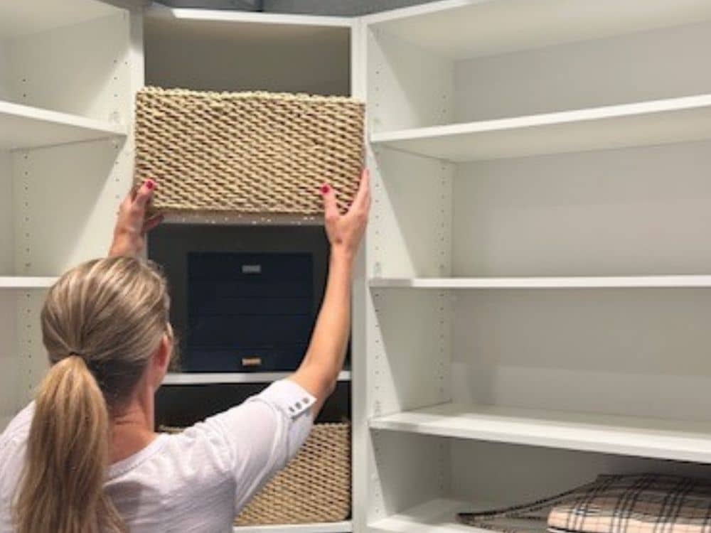 A professional organizer putting a bin in a closet