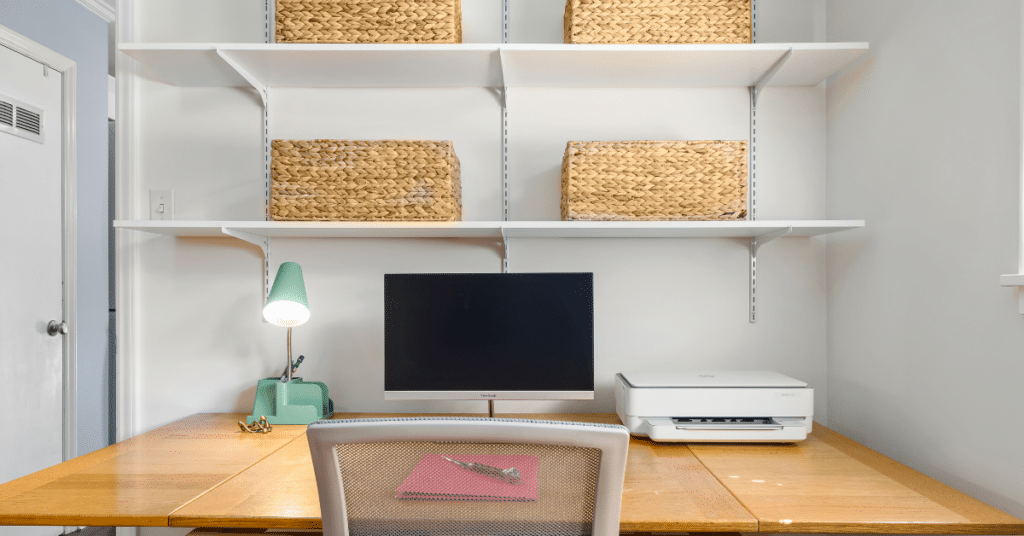 home office with desk and computer, and pretty woven baskets on shelves for office clutter