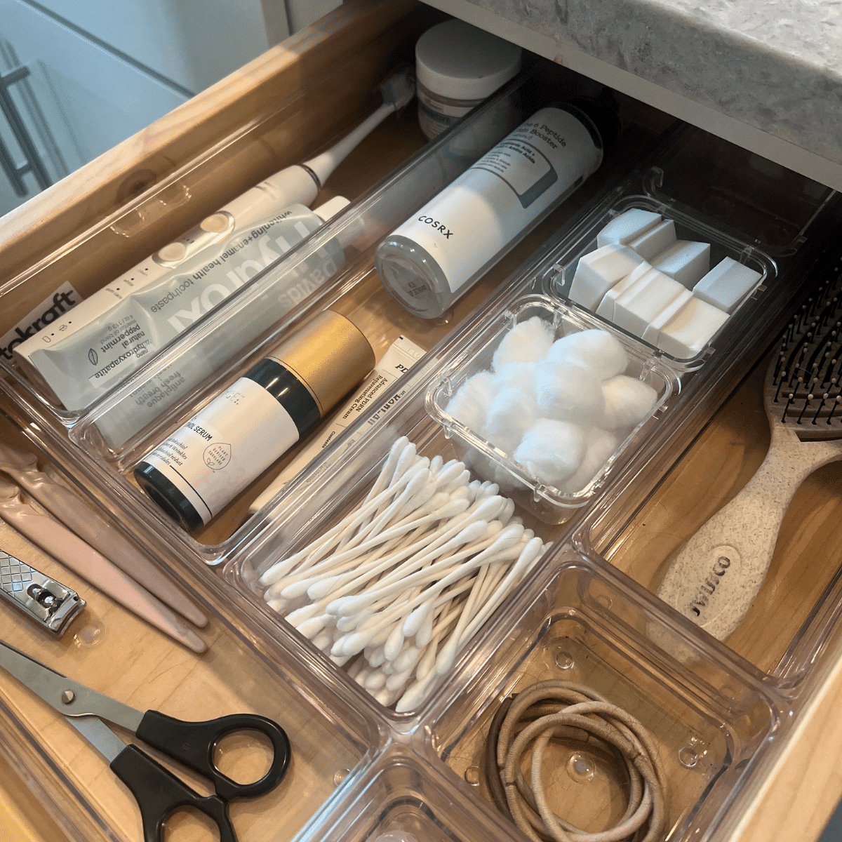 Bathroom drawer organized with acrylic bins