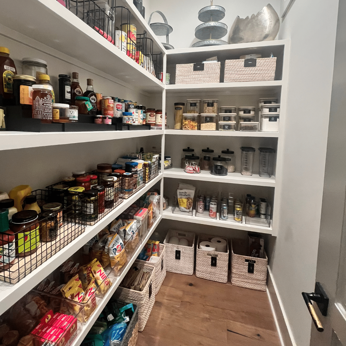 Organized walk in pantry with labeled baskets and other organizing product